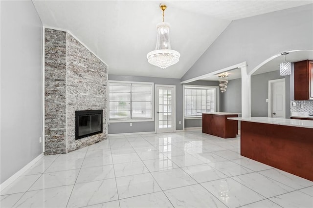 2140 Carol Sue Ave, Terrytown, LA 70056 - unfurnished living room featuring vaulted ceiling, an inviting chandelier, marble finish floor, and plenty of natural light