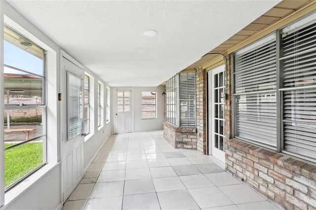 2140 Carol Sue Ave, Terrytown, LA 70056 - unfurnished sunroom with tile patterned floors, a textured ceiling, and brick wall