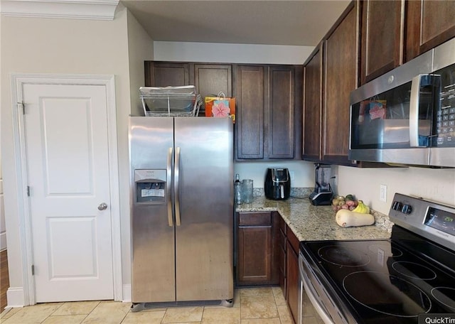2680 Lavender St, New Orleans, LA 70122 - kitchen with stainless steel appliances, dark brown cabinets, light stone countertops, and light tile patterned floors