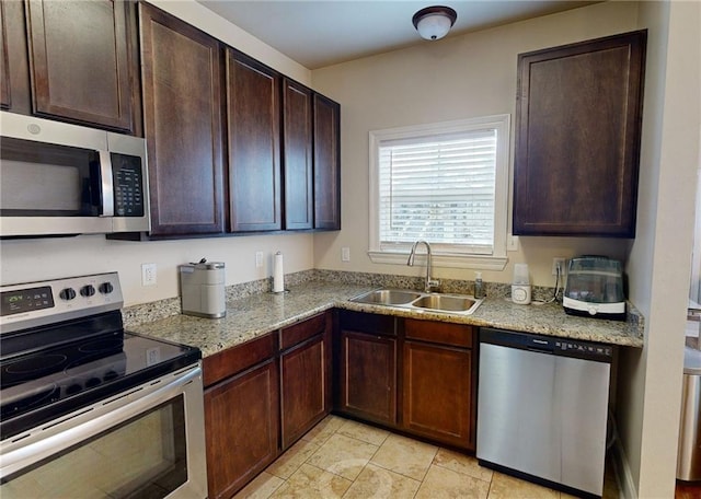 2680 Lavender St, New Orleans, LA 70122 - kitchen featuring stainless steel appliances, dark brown cabinets, light stone counters, and light tile patterned flooring