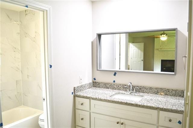 full bathroom featuring toilet, ceiling fan, bathtub / shower combination, and vanity