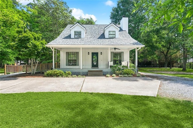 cape cod house featuring a chimney, a porch, board and batten siding, and a front yard