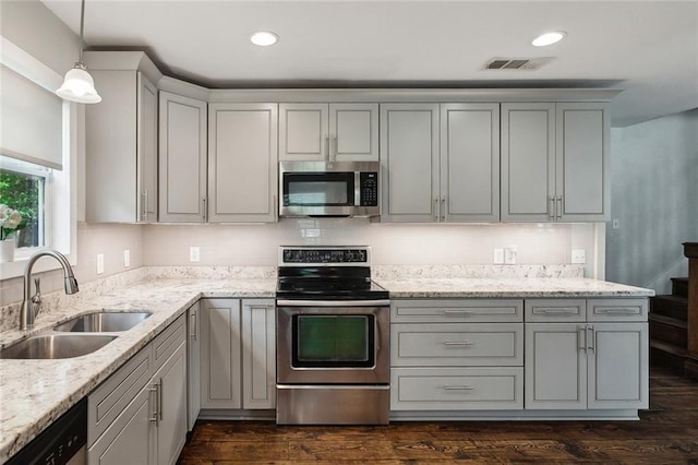kitchen featuring appliances with stainless steel finishes, visible vents, gray cabinetry, and a sink