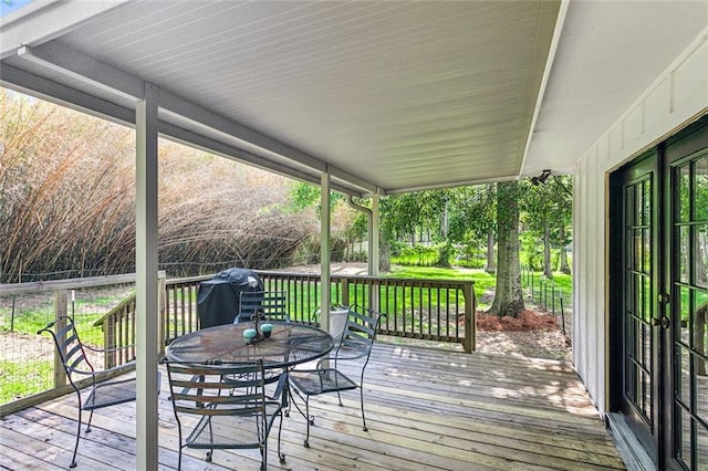 wooden deck featuring a grill and outdoor dining space