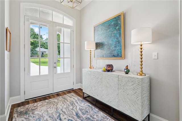 entrance foyer with a chandelier, wood finished floors, french doors, and baseboards