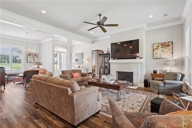 living room with ornamental molding, visible vents, a ceiling fan, a fireplace with flush hearth, and dark wood-type flooring