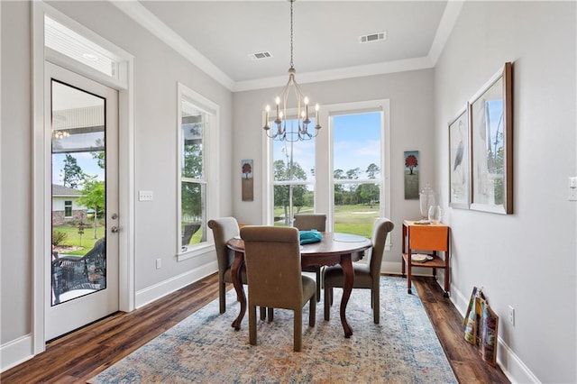 dining room featuring ornamental molding, dark wood-style floors, an inviting chandelier, and visible vents