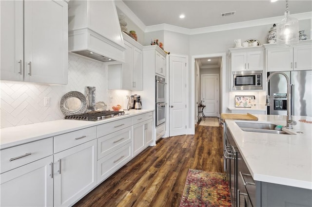 kitchen with appliances with stainless steel finishes, ornamental molding, custom exhaust hood, and visible vents