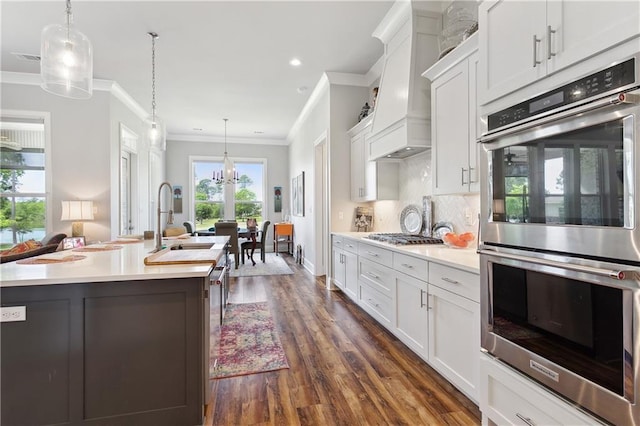 kitchen featuring ornamental molding, a sink, appliances with stainless steel finishes, and light countertops