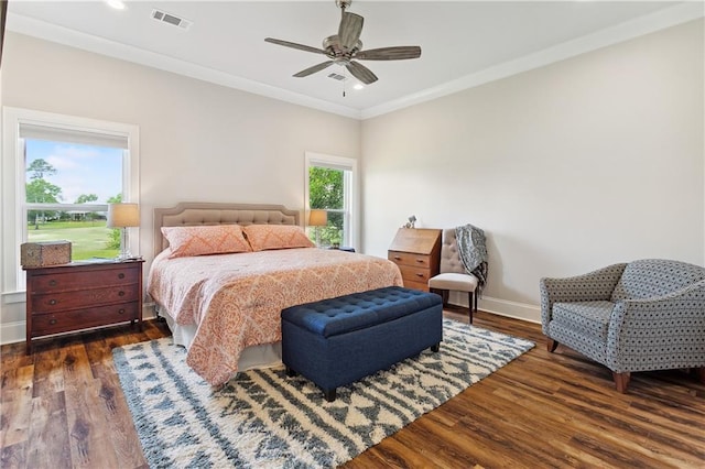 bedroom featuring crown molding, a ceiling fan, visible vents, baseboards, and wood finished floors