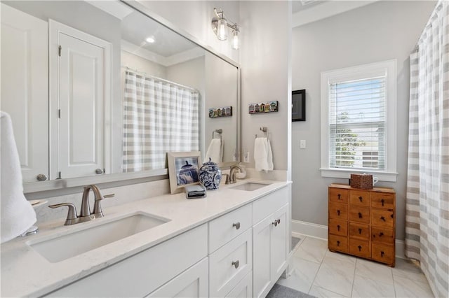 bathroom with double vanity, baseboards, marble finish floor, and a sink