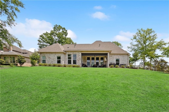 back of property with a lawn and an attached garage