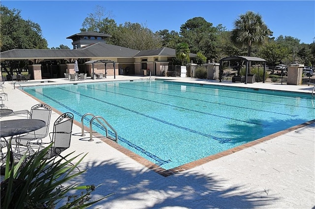 pool featuring fence and a patio area