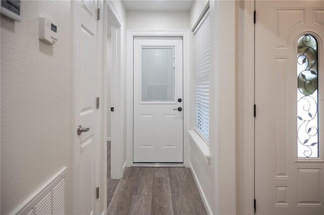 208 Bedford St, La Place, LA 70068 - doorway to outside featuring dark wood-style flooring and healthy amount of natural light