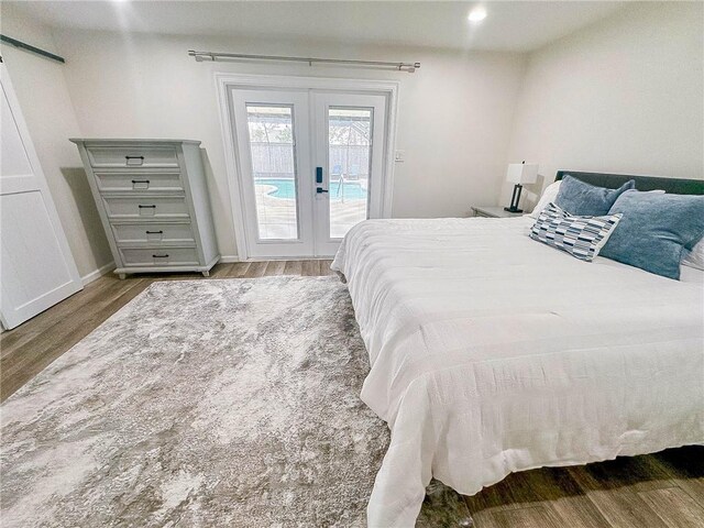 208 Bedford St, La Place, LA 70068 - bedroom featuring access to exterior, french doors, wood finished floors, a barn door, and baseboards