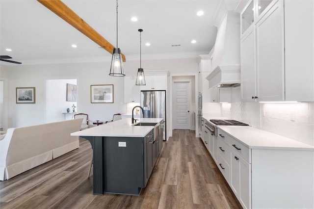 kitchen featuring tasteful backsplash, custom exhaust hood, white cabinetry, light countertops, and wood finished floors