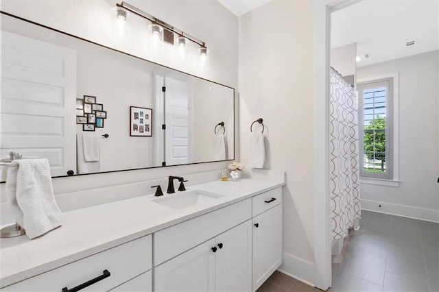 bathroom featuring curtained shower, tile patterned flooring, vanity, and baseboards