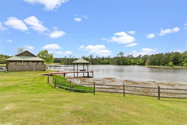 view of dock featuring a gazebo, a water view, and a lawn