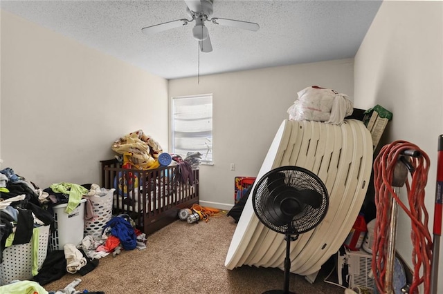 carpeted bedroom featuring a textured ceiling, a ceiling fan, and baseboards