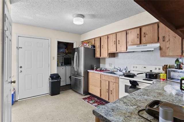 kitchen with a sink, independent washer and dryer, stainless steel appliances, under cabinet range hood, and a textured ceiling