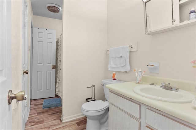 full bath featuring toilet, vanity, and wood finished floors