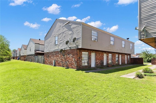 back of property with brick siding and a yard