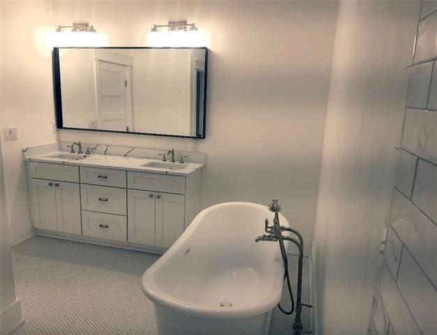 bathroom featuring double vanity, a sink, and a freestanding bath