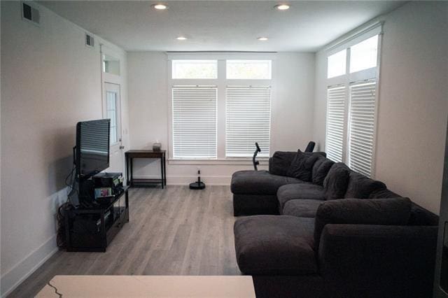 living area with baseboards, recessed lighting, wood finished floors, and visible vents