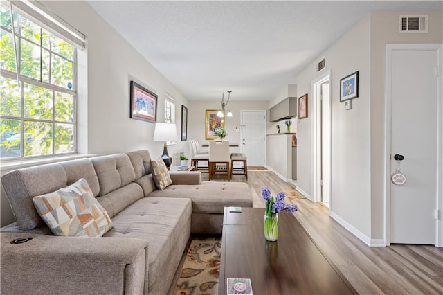 living room featuring visible vents, a healthy amount of sunlight, and light wood finished floors