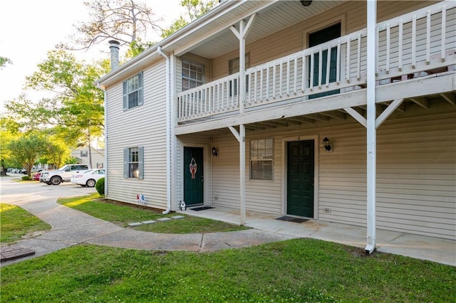 exterior space featuring a chimney and a balcony