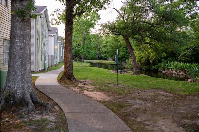 view of community with a yard and a water view