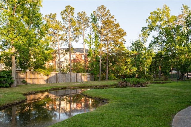 view of yard with fence and a water view