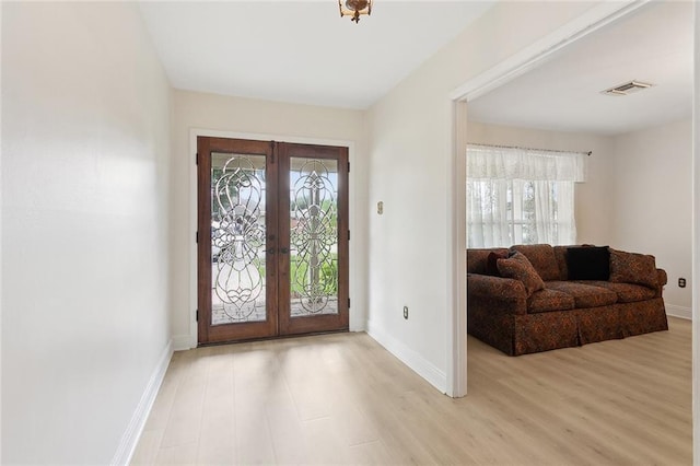 entryway with french doors, baseboards, and light wood-style floors