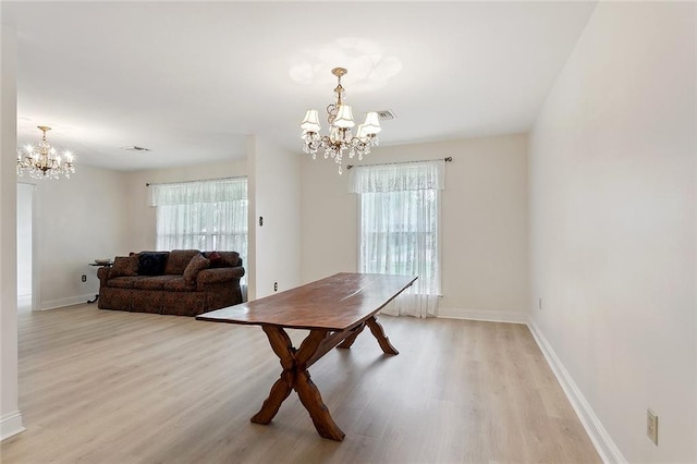 dining space with visible vents, light wood-style floors, a notable chandelier, and baseboards