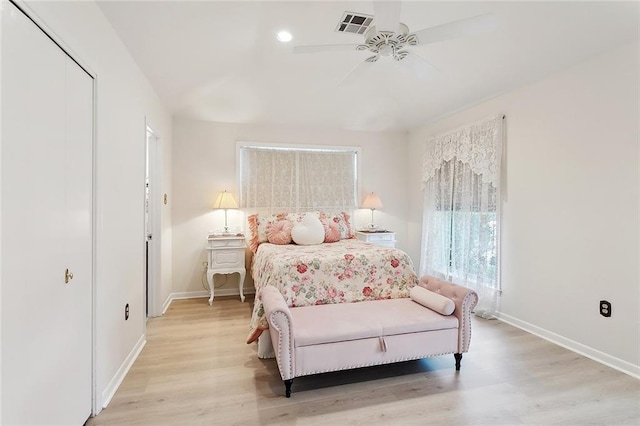 bedroom with baseboards, visible vents, and light wood finished floors
