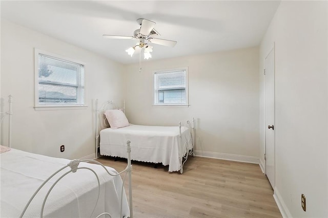 bedroom featuring ceiling fan, light wood-type flooring, and baseboards