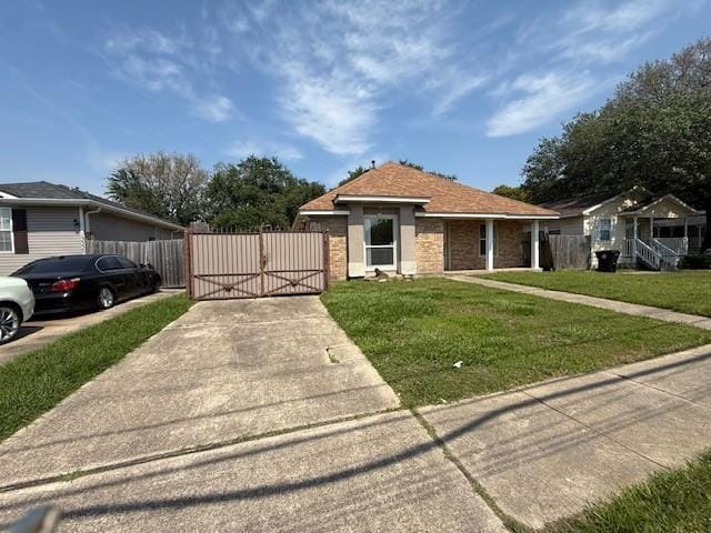view of front of house featuring driveway, fence, a gate, and a front lawn
