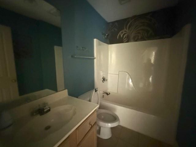 bathroom featuring vanity, tile patterned flooring, tub / shower combination, and toilet