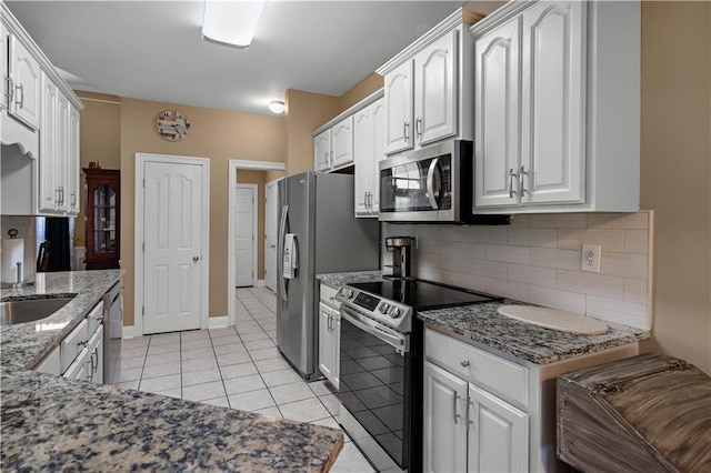 kitchen featuring white cabinets, stainless steel appliances, backsplash, and stone counters