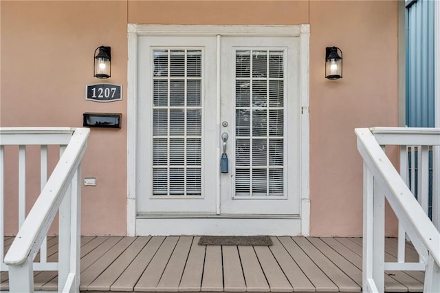 view of exterior entry with stucco siding and french doors