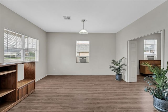 interior space featuring cooling unit, visible vents, wood finished floors, and baseboards