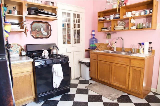 kitchen featuring open shelves, a sink, gas stove, light countertops, and light floors