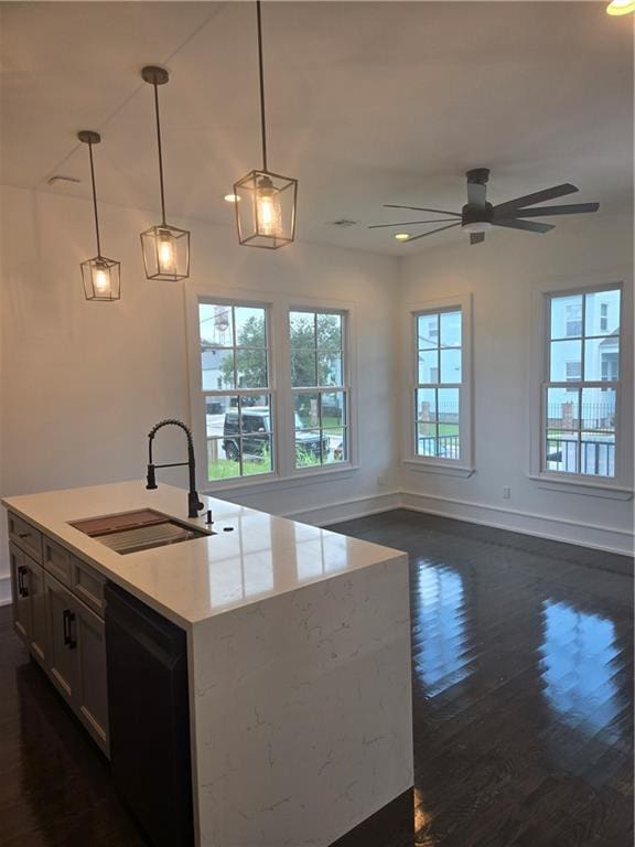 5453 Chartres St, New Orleans, LA 70117 - kitchen with dishwasher, dark wood-style flooring, pendant lighting, a ceiling fan, and a center island with sink