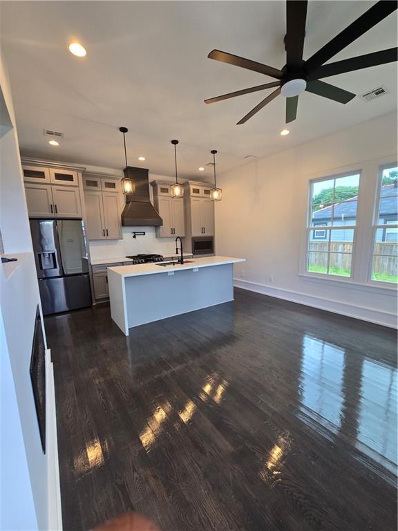 5453 Chartres St, New Orleans, LA 70117 - kitchen featuring custom range hood, stainless steel appliances, recessed lighting, light countertops, and dark wood finished floors
