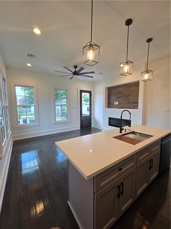 5453 Chartres St, New Orleans, LA 70117 - kitchen featuring dishwasher, dark wood-style floors, light countertops, pendant lighting, and a ceiling fan