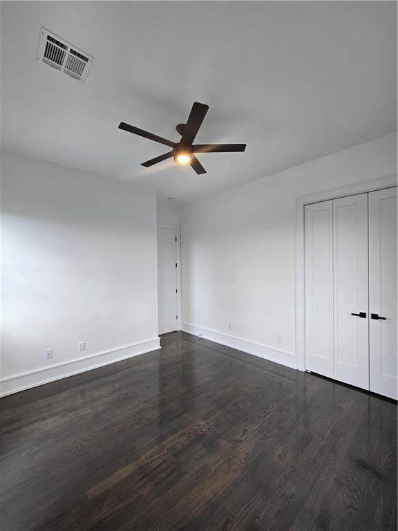 5453 Chartres St, New Orleans, LA 70117 - unfurnished bedroom featuring dark wood-style floors, ceiling fan, and a closet