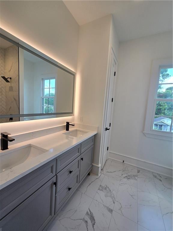 5453 Chartres St, New Orleans, LA 70117 - bathroom featuring double vanity, healthy amount of natural light, tiled shower, and marble look tile flooring