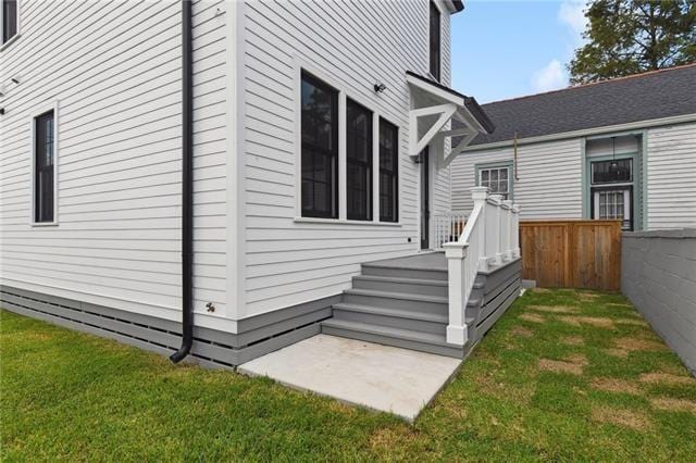 view of home's exterior with fence and a yard