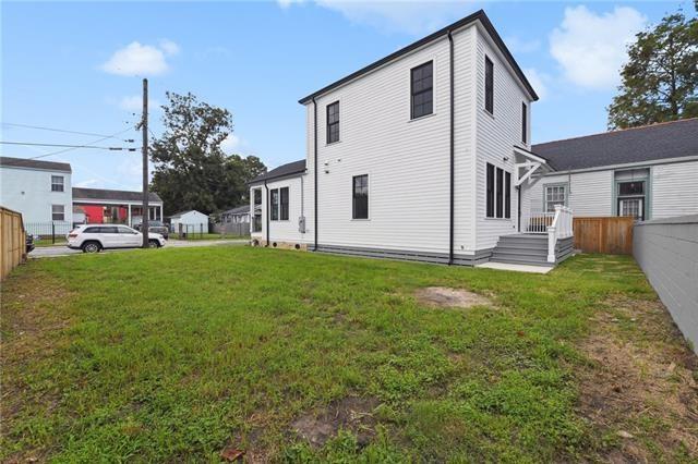 back of house featuring fence and a yard