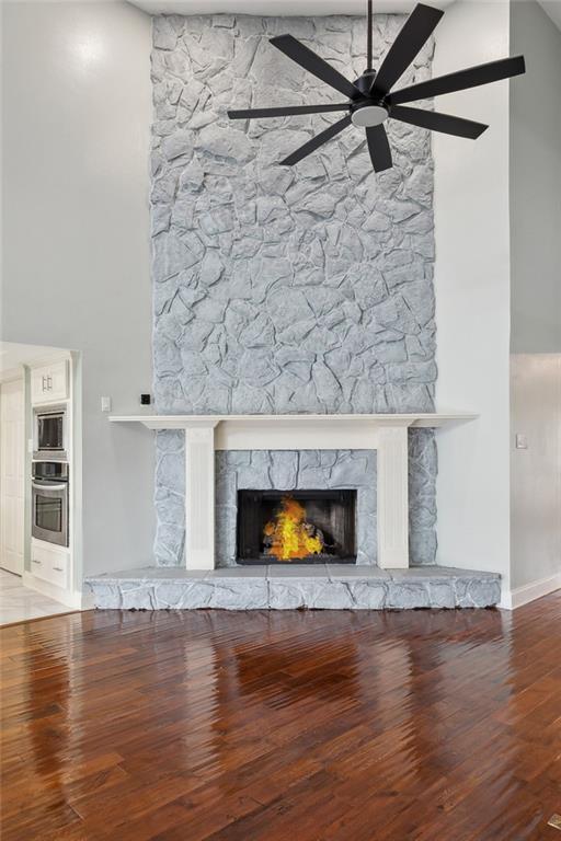 4435 Francecso Rd, New Orleans, LA 70129 - details featuring appliances with stainless steel finishes, baseboards, a fireplace, wood finished floors, and a ceiling fan